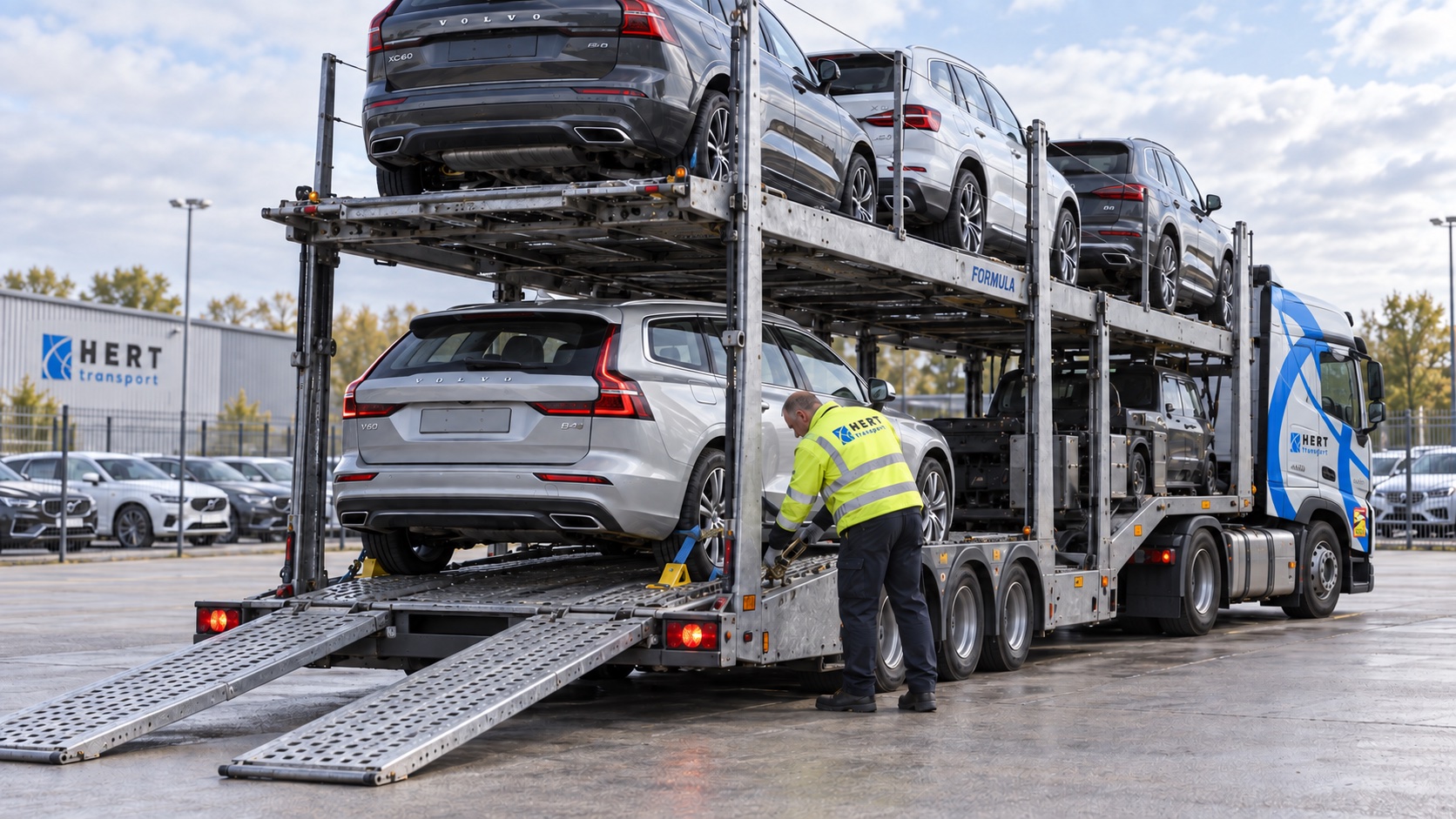 Driver checking a vehicle wheel restraint on a Hert open car carrier